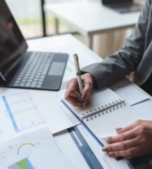 Finance,,Asian,Female,Office,Worker,Sitting,And,Taking,Notes,On