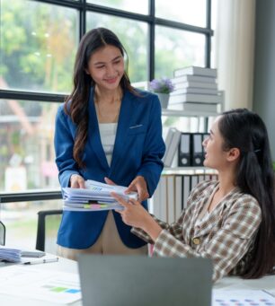 Two,Beautiful,Asian,Businesswomen,In,Conversation,Exchange,Ideas,,Present,Analysis