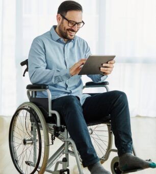 Portrait,Of,A,Young,Man,In,Wheelchair,Using,A,Tablet,