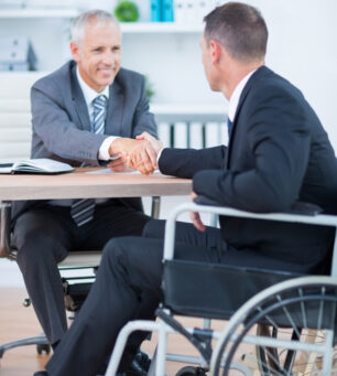 Businessman,In,Wheelchair,Shaking,Hands,With,Colleague,In,The,Office