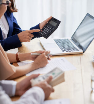 Real estate agent helping senior couple to calculate mortgage payment and down payment