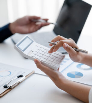 Company meeting room has businessmen and finance managers meeting together on finance topics, they are looking at information on documents and discussing together. Concept company financial management